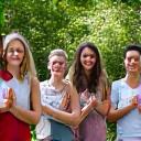 A diverse group of adults in Nashville participating in a laughter yoga session outdoors, symbolizing holistic health and community support.